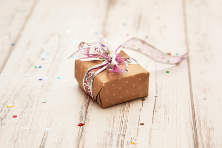 Rustic white wooden table with confetti and craft present box. Christmas conceptの写真素材