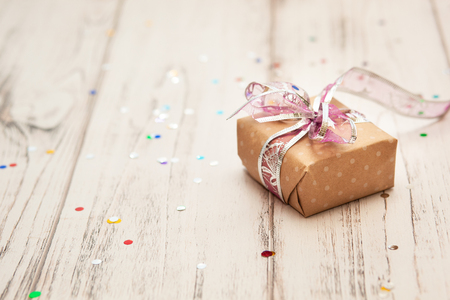 Rustic white wooden table with confetti and craft present box. Christmas conceptの写真素材
