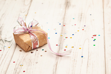 Rustic white wooden table with confetti and craft present box. Christmas conceptの写真素材