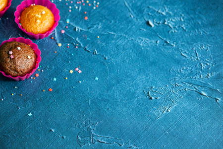 Delicious chocolate and vanilla cupcakes with sweet topping on textured concrete table, top view. Sweet pastriesの写真素材