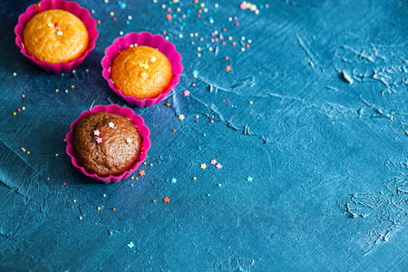 Delicious chocolate and vanilla cupcakes with sweet topping on textured concrete table, top view. Sweet pastriesの写真素材
