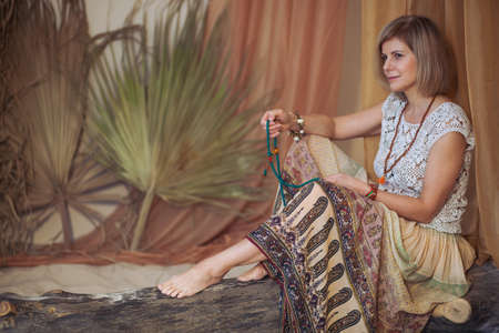 Calm woman meditating at meditate place in lotus position. The girl is dressed in ethnic clothes. natural materialsの写真素材