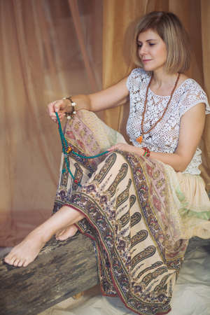 Calm woman meditating at meditate place in lotus position. The girl is dressed in ethnic clothes. natural materialsの写真素材