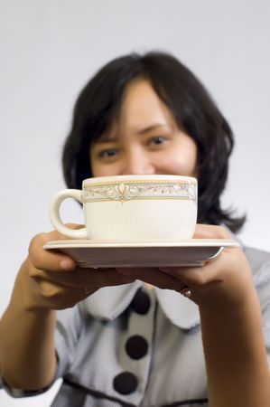 Beautiful Asian Business Woman drink a cup of coffee and sitting at the tableの写真素材