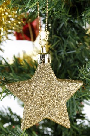 Christmas gold star hanging on tree over white backgroundの写真素材