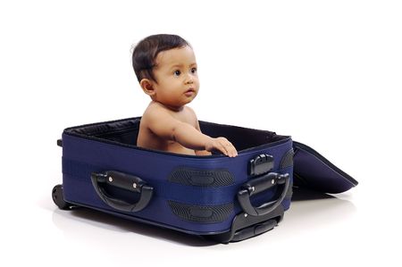 Baby girl in the blue suitcase on white background. Ready to travelの写真素材