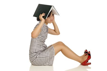 Woman Put book at her head isolated on white backgroundの写真素材