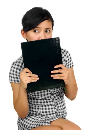 Woman holding book on the face isolated on white backgroundの写真素材