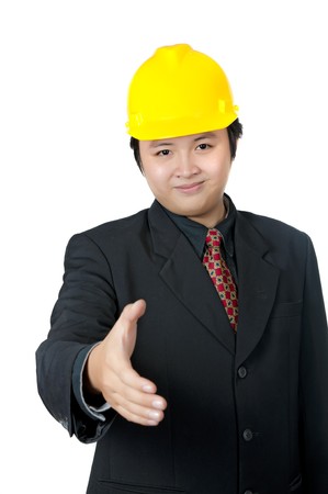 Business man wearing yellow helmet want to shake hand isolated over white backgroundの写真素材
