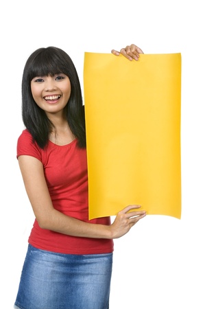 Asian woman in red shirt holding yellow sign/banner isolated over white backgroundの写真素材
