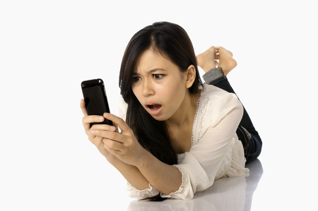 Asian woman shock see news on the cellphone, isolated on white backgroundの写真素材