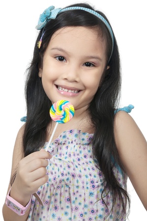 Mix race asian caucasian girl eating lollipop isolated over white backgroundの写真素材