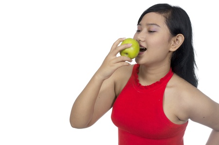 Fat asian woman eat green apple isolated over white backgroundの写真素材