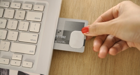 Credit card insert inside laptop on the wooden deskの写真素材