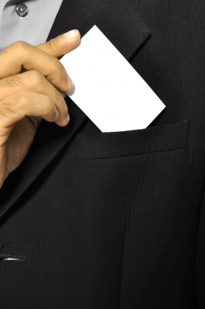 Business man putting a blank business card in his suit pocketの写真素材