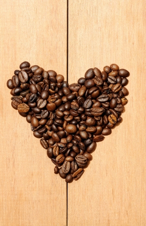 Heart shape coffee bean shot on the wooden backgroundの写真素材