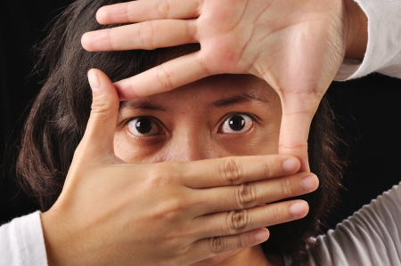 A woman framing her eyes with her handの写真素材