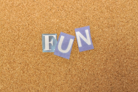 Fun word made from newspaper letter shot over pinboard backgroundの写真素材