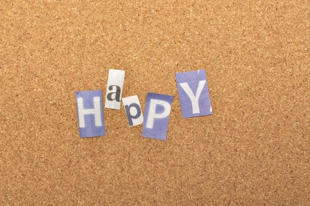 Happy word made from newspaper letter shot over pinboard backgroundの写真素材