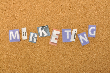 Marketing word made from newspaper letter shot over pinboard backgroundの写真素材
