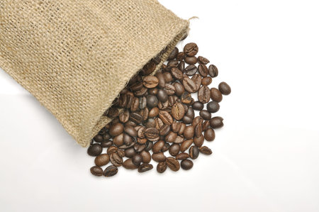 Coffee beans in burlap sack shot over white background