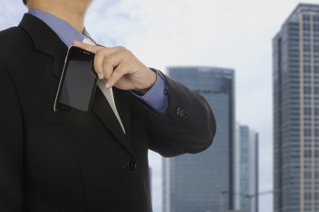 Man in business suit holding cellphone. You can put your design on the phoneの写真素材