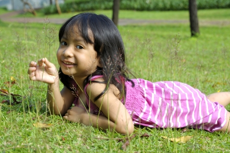 Cute little girl on the park in the summer timeの写真素材