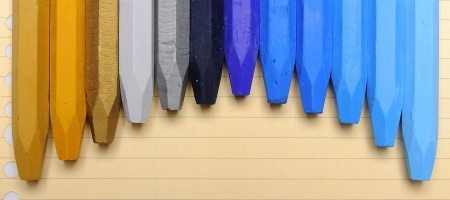 Row of colorful crayon over stripe patern paperの写真素材