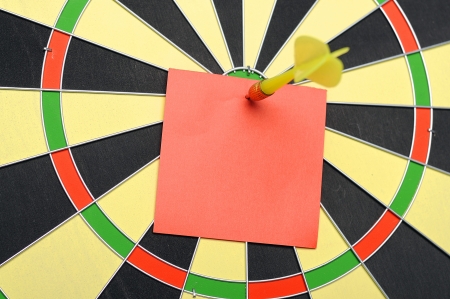 Red paper note with dart arrow on dartboardの写真素材