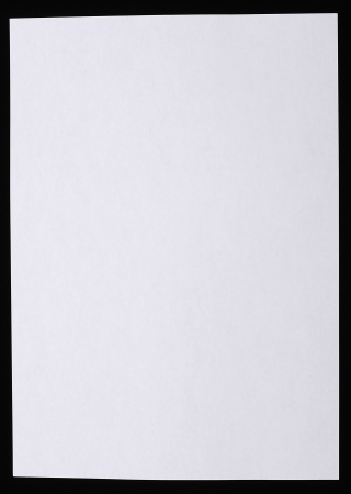 A sheet of white paper isolated over black backgroundの写真素材