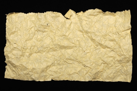 Crumpled brown paper texture isolated over black backgroundの写真素材
