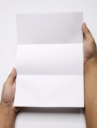 Male hand holding folded blank A4 copy space letterの写真素材