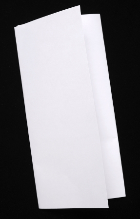 Folded paper isolated over black background. You can put your design on the paperの写真素材
