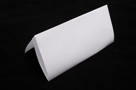 Folded paper isolated over black background. You can put your design on the paperの写真素材