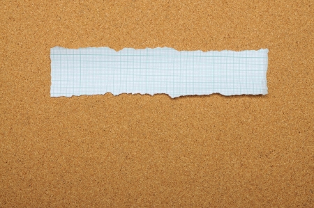 Blue torn piece of paper over brown backgroundの写真素材