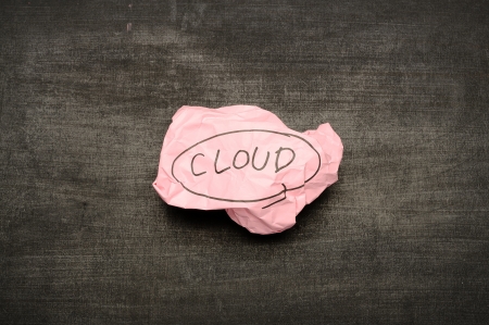 Cloud computing concept. Cloud writing on crumpled paper on blackboardの写真素材
