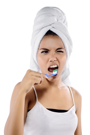 Portrait of funny asian smiling woman isolated on white background brushing her teethの写真素材