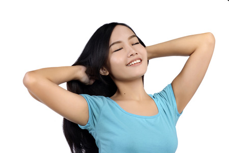 Woman in blue shirt looking happy isolated over white backgroundの写真素材