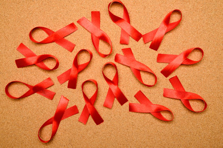 Lots of red ribbon on corkboard. AIDS awareness concept