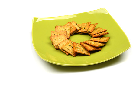 Biscuit or snack on the green bowl. Isolated on white.の写真素材