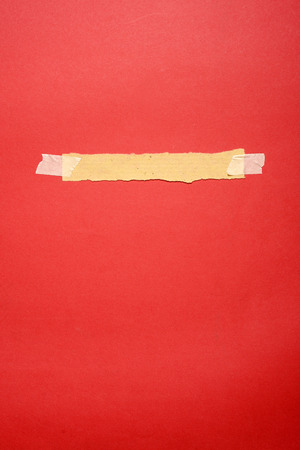 Torn paper with tape on red paper の写真素材