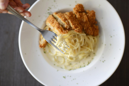 woman hand holding delicious spaghetti on fork の写真素材