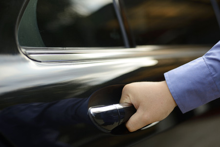 Man hand on handle is opening a car doorの写真素材