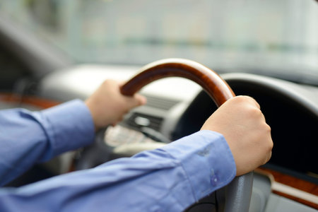Close up of man hand holding a steering wheel in a car