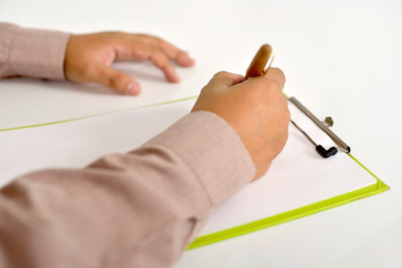 Man writing on blank paper on clipboard.の写真素材