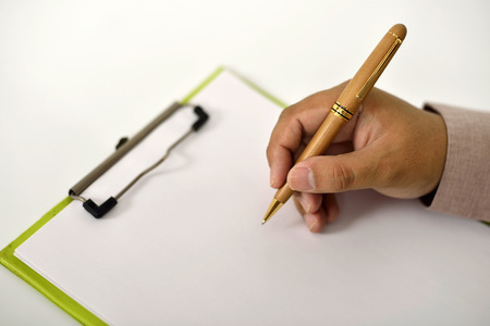 Business man writing something on the clipboardの写真素材