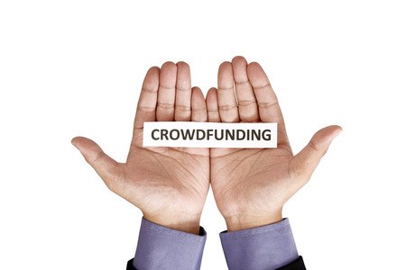 Hand holding paper with crowdfunding text isolated over white の写真素材