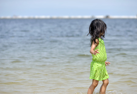 Asian girl playing on the beachの写真素材
