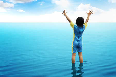 Back view of little girl looking the ocean. Vacation concept imageの写真素材