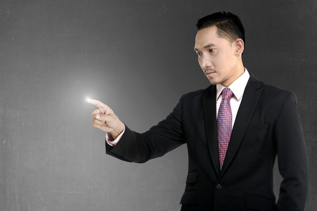 Asian business man pointing something with confident lookの写真素材